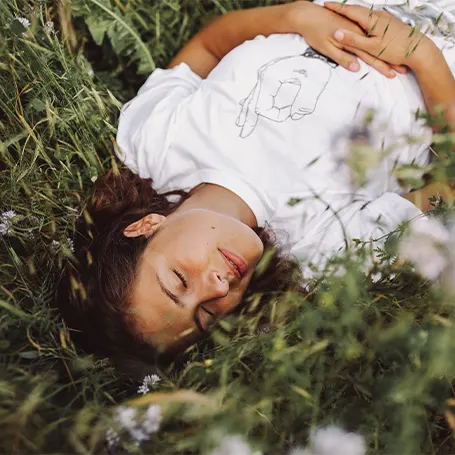 Una imagen de una mujer durmiendo al aire libre en la hierba