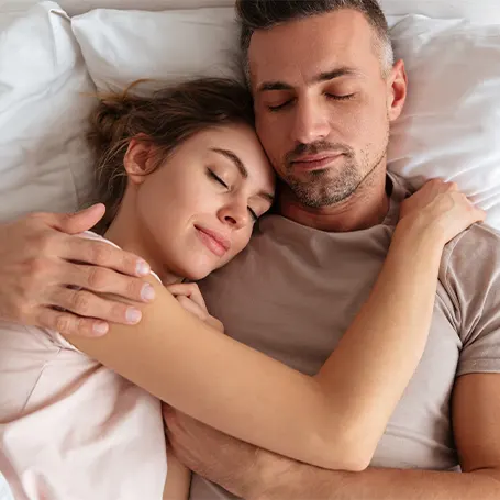 a couple sleeping in a bed