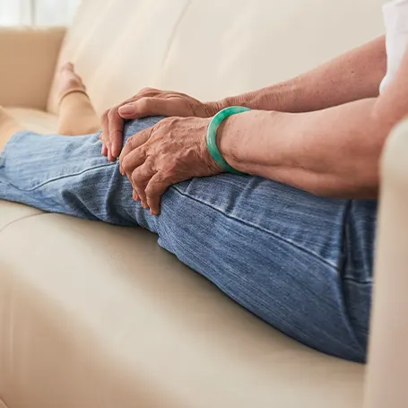 Una imagen de una mujer anciana tocándose la rodilla