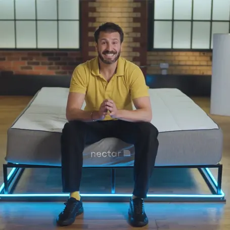 An image of a TSA reviewer sitting on the nectar memory foam mattress