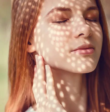 Una imagen de una mujer con la luz brillando en su cara